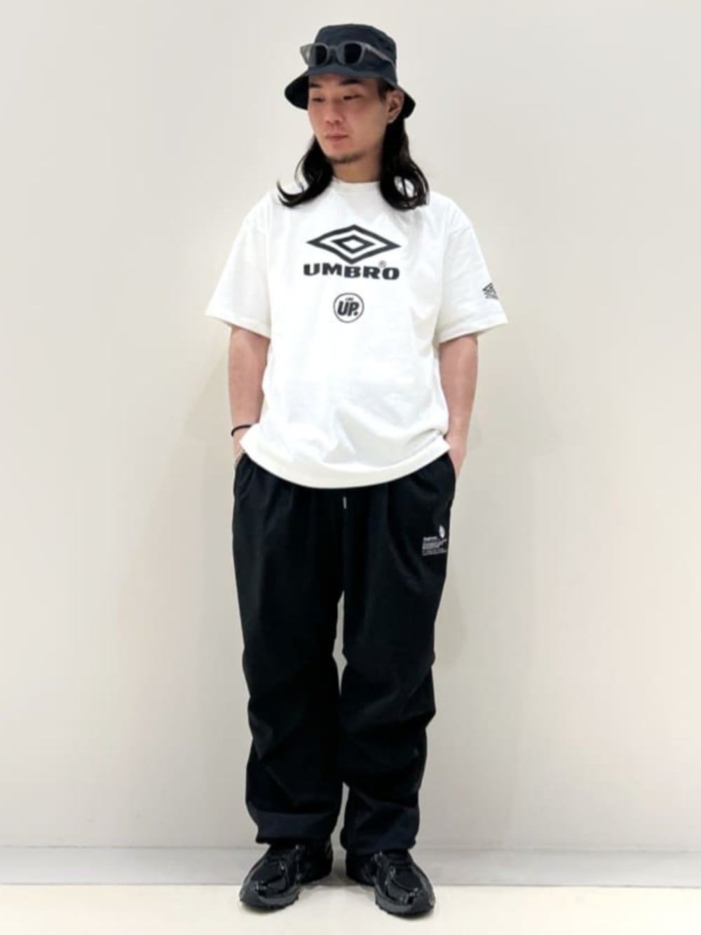 「umbro、ナイロンパンツ、イージーパンツ、ワイドパンツ、NEW ERA、New Balance、スニーカー、スポーツミックス、メンズファッション、ロゴTシャツ、夏だ！Tシャツ着よう！、フェスコーデ、夏コーデ、お出かけコーデ、フェススタイル」｜「NEW ERAのNEW ERA / ニューエラ OD BKT01 PACK BSC TECH AIR（ハット、ブラック系）」を使った、417 officialさん（メンズ・170cm）の夏コーディネートの1枚目の写真