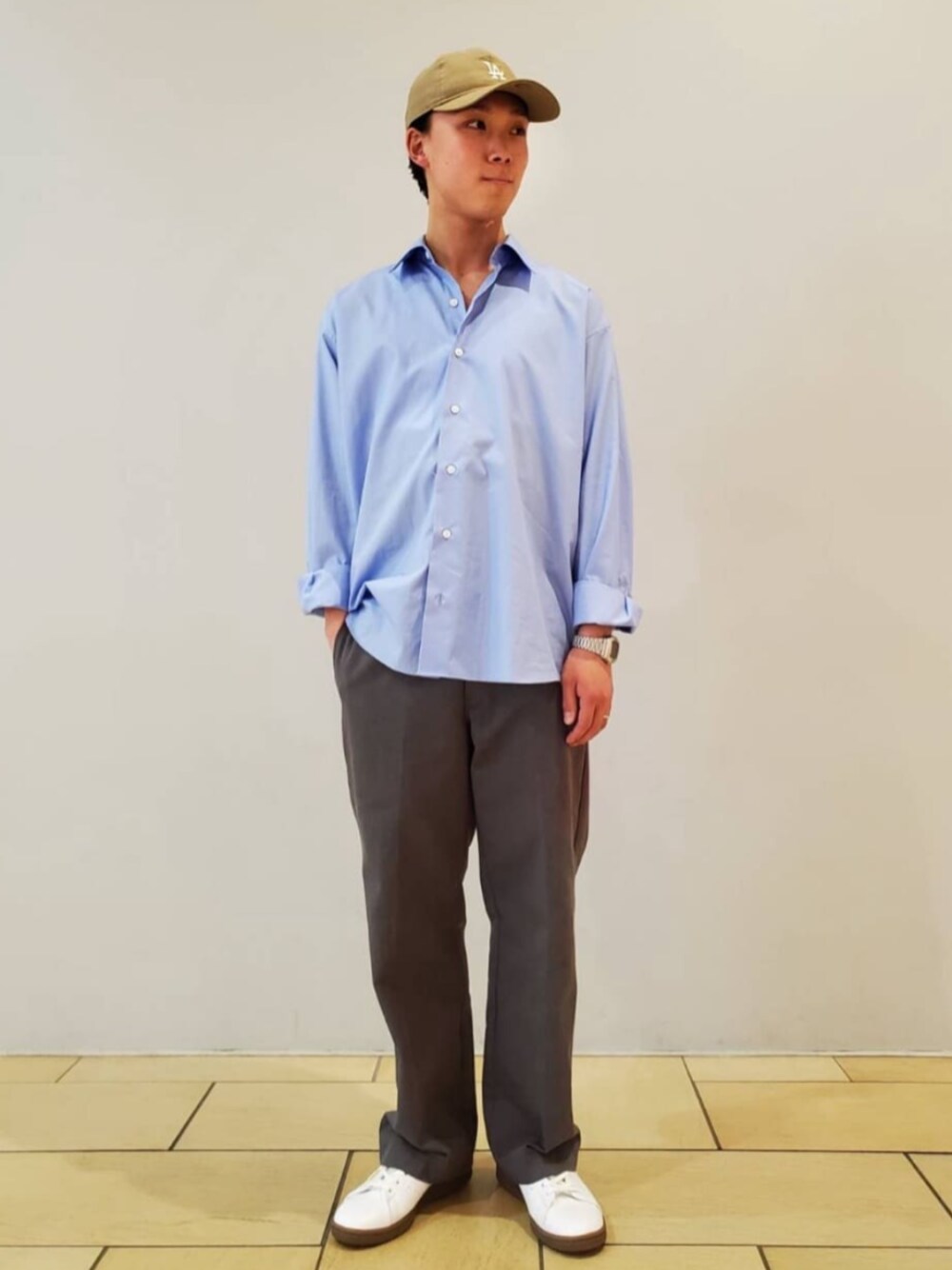 ブルー系のシャツ/ブラウス、ホワイト系のスニーカー、グレー系のスラックスを着用したメンズの春コーディネートの1枚目の写真