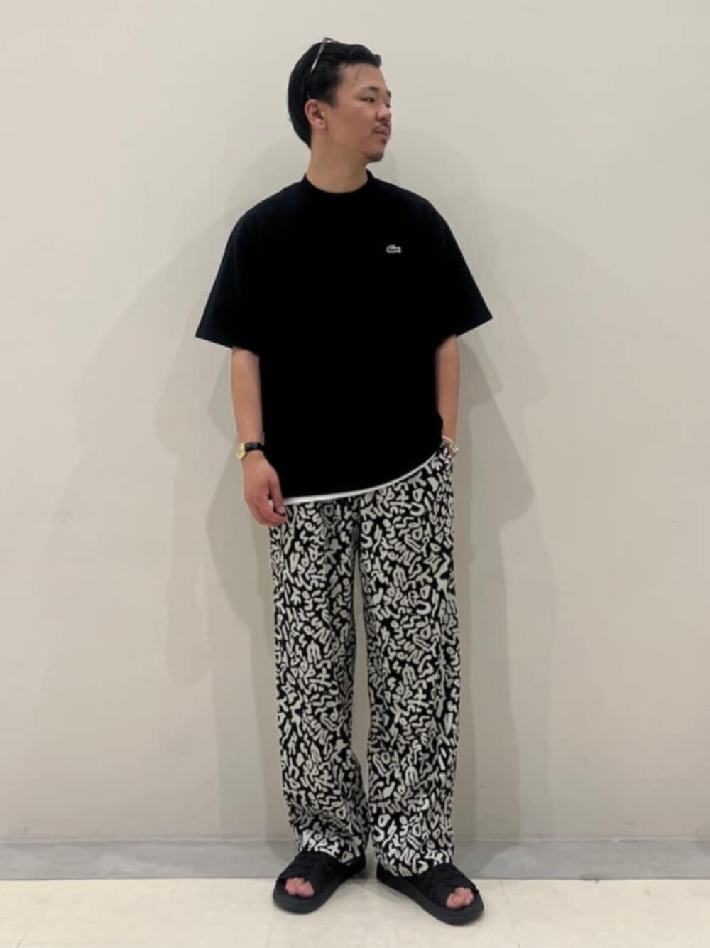 ブラック系のTシャツ/カットソー、ブラック系のその他パンツ、ブラック系のサンダルを着用したメンズの春コーディネートの1枚目の写真