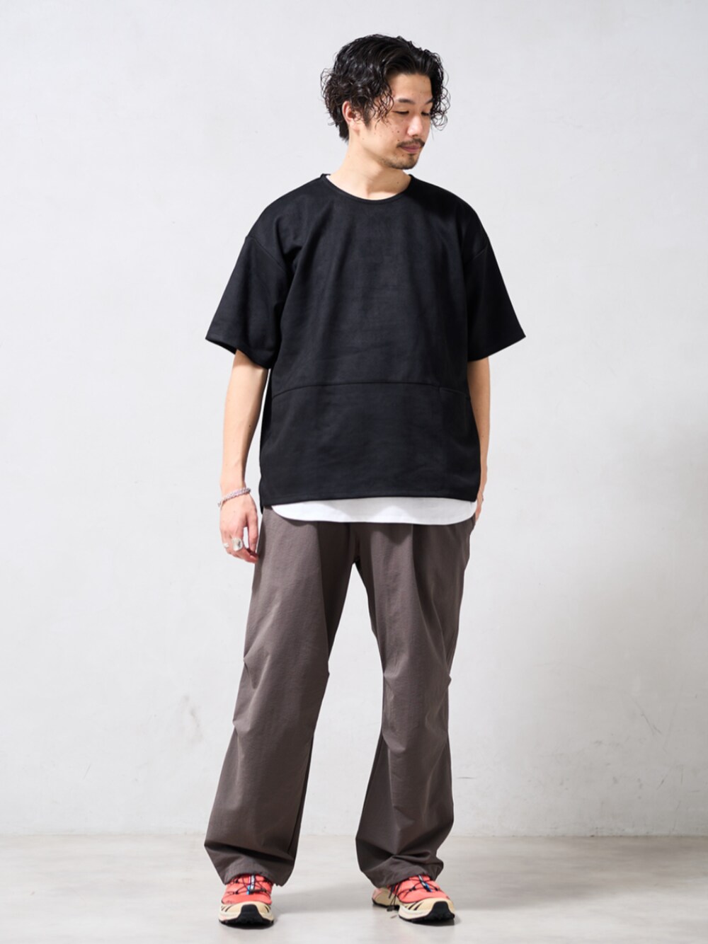 ブラック系のTシャツ/カットソー、ベージュ系のスラックス、ホワイト系のタンクトップを着用したメンズの春コーディネートの1枚目の写真