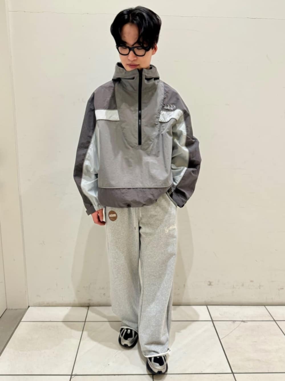 グレー系のスウェットパンツ、グレー系のマウンテンパーカー、ブラック系のスニーカーを着用したメンズの春コーディネートの1枚目の写真