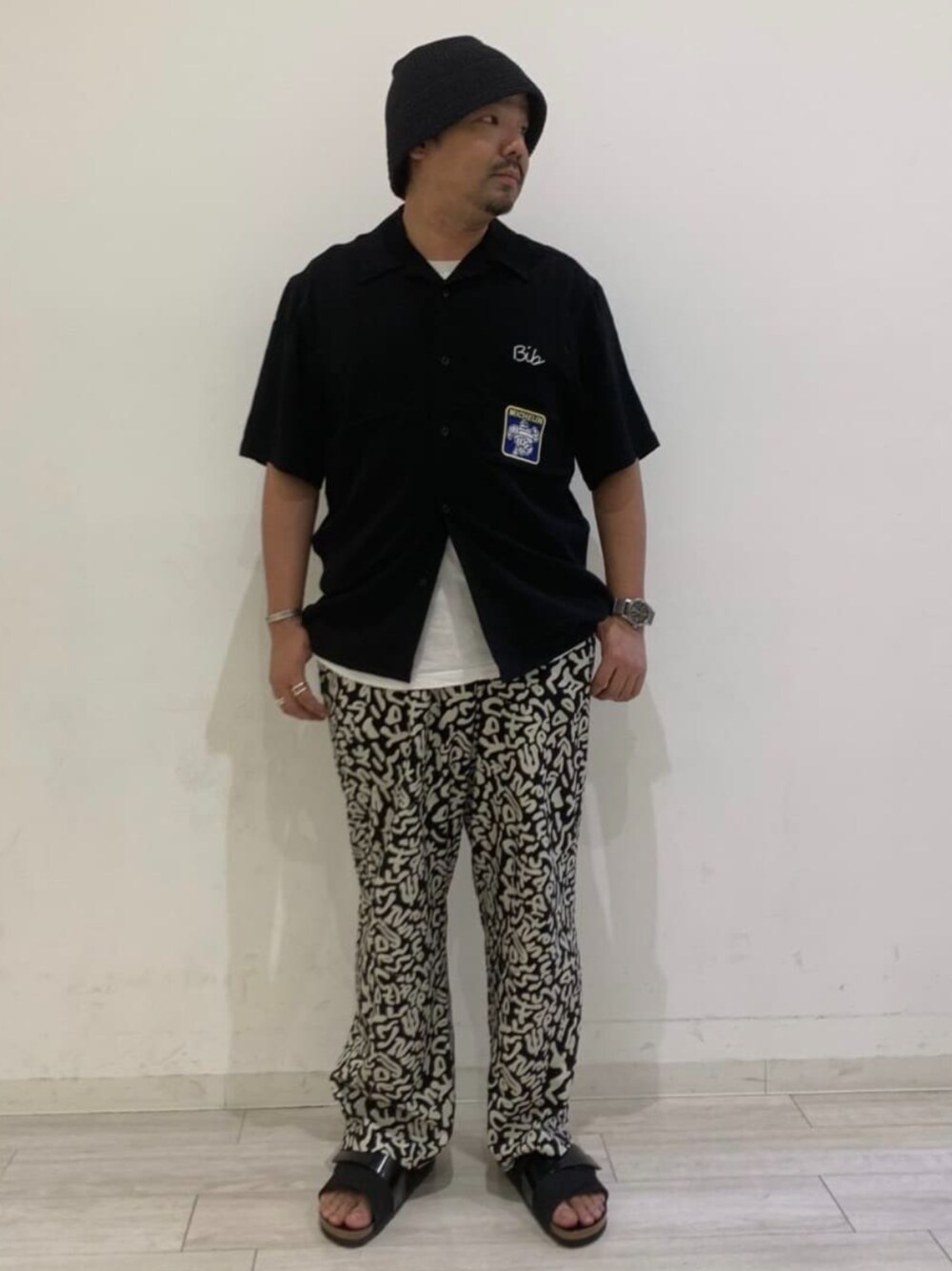 ブラック系のその他パンツ、ブラック系のシャツ/ブラウス、ブラック系のサンダルを着用したメンズの春コーディネートの1枚目の写真