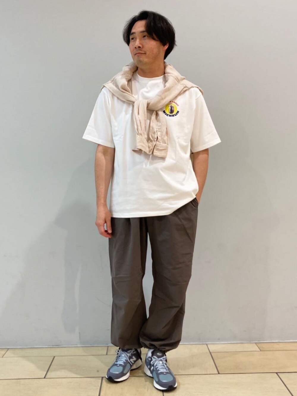 ベージュ系のスラックス、ベージュ系のシャツ/ブラウス、ホワイト系のTシャツ/カットソーを着用したメンズの春コーディネートの1枚目の写真