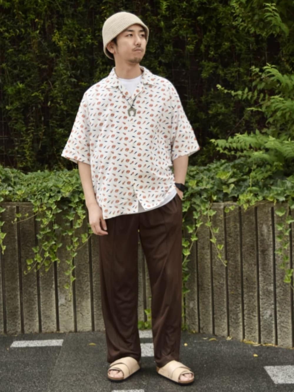 ホワイト系のシャツ/ブラウス、ブラウン系のスラックス、ベージュ系のサンダルを着用したメンズの夏コーディネートの1枚目の写真