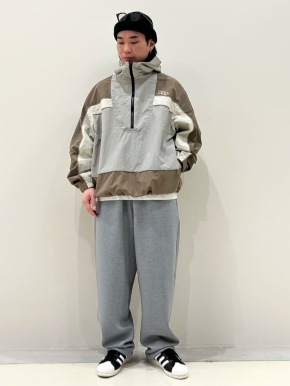 ベージュ系のマウンテンパーカー、グレー系のスウェットパンツを着用したメンズの春コーディネートの1枚目の写真