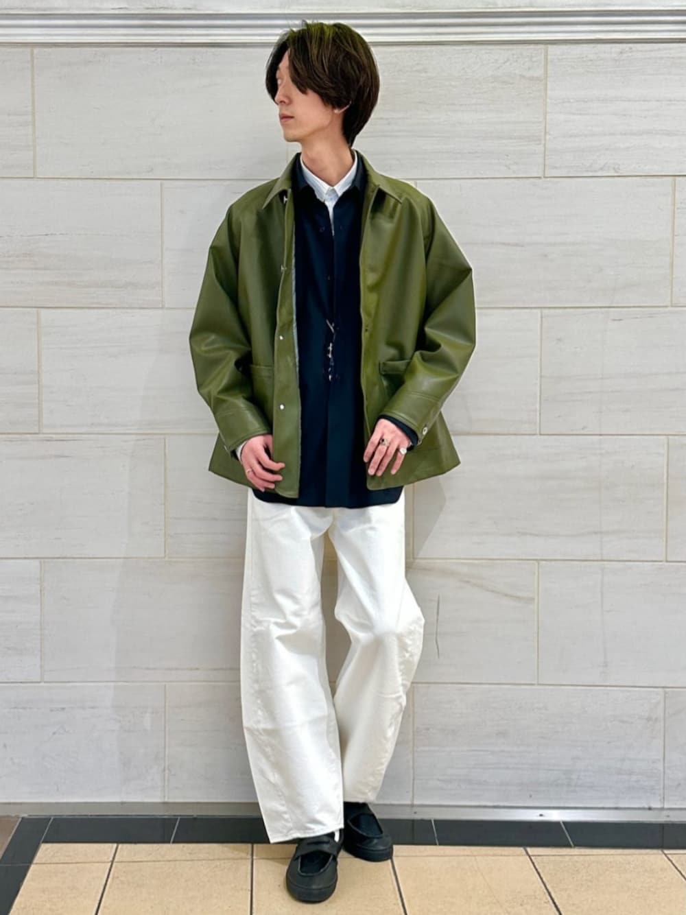 ブルー系のシャツ/ブラウス、グリーン系のライダースジャケット、ホワイト系のデニムパンツを着用したメンズの春コーディネートの1枚目の写真