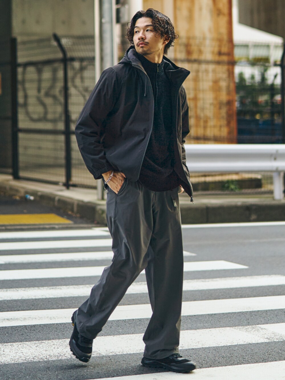 グレー系のその他パンツ、ブラック系のスニーカー、ブラック系のマウンテンパーカーを着用したメンズの秋コーディネートの1枚目の写真