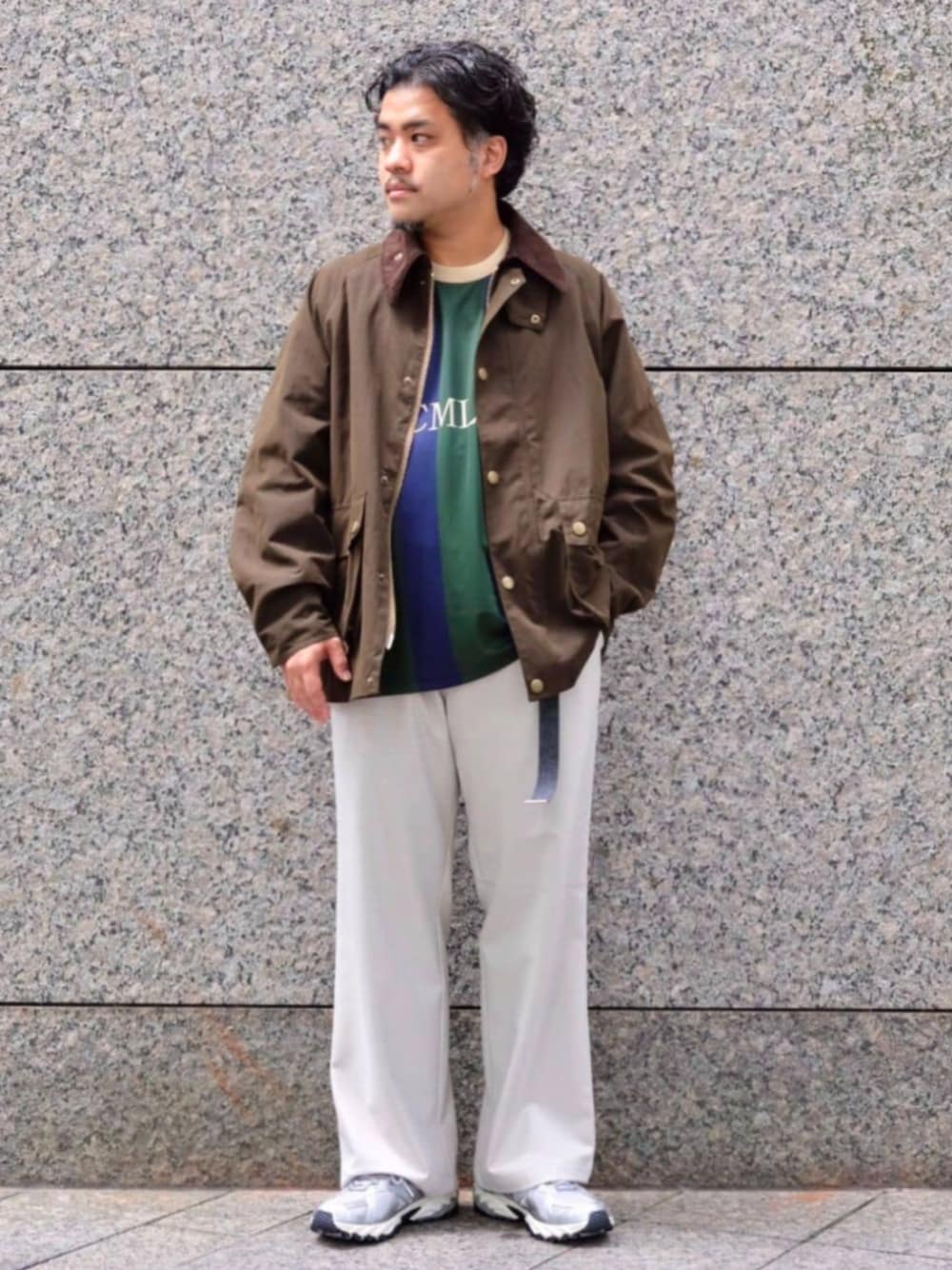 グリーン系のナイロンジャケット、ブルー系のTシャツ/カットソー、ホワイト系のスラックスを着用したメンズの秋コーディネートの1枚目の写真