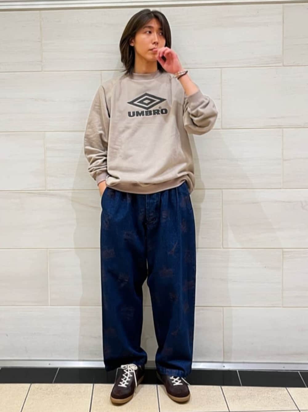 ベージュ系のスウェット、ブルー系のデニムパンツ、ブラウン系のスニーカーを着用したメンズの秋コーディネートの1枚目の写真