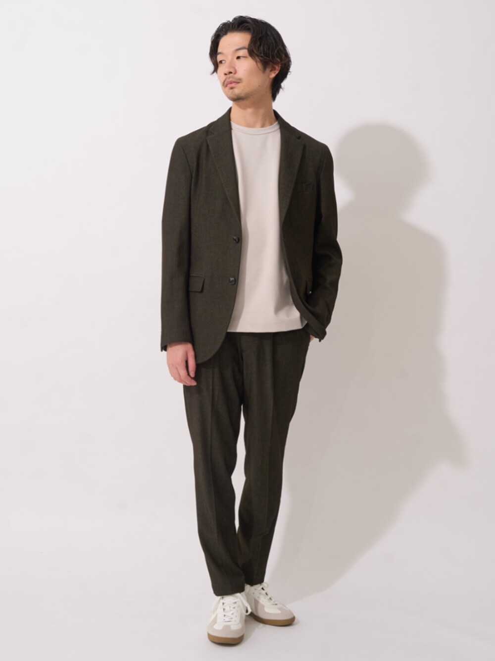 ホワイト系のスニーカー、グリーン系のセットアップ、グレー系のTシャツ/カットソーを着用したメンズの秋コーディネートの1枚目の写真