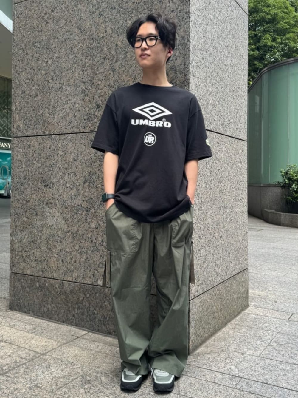 ブラック系のTシャツ/カットソー、グリーン系のカーゴパンツを着用したメンズの夏コーディネートの1枚目の写真