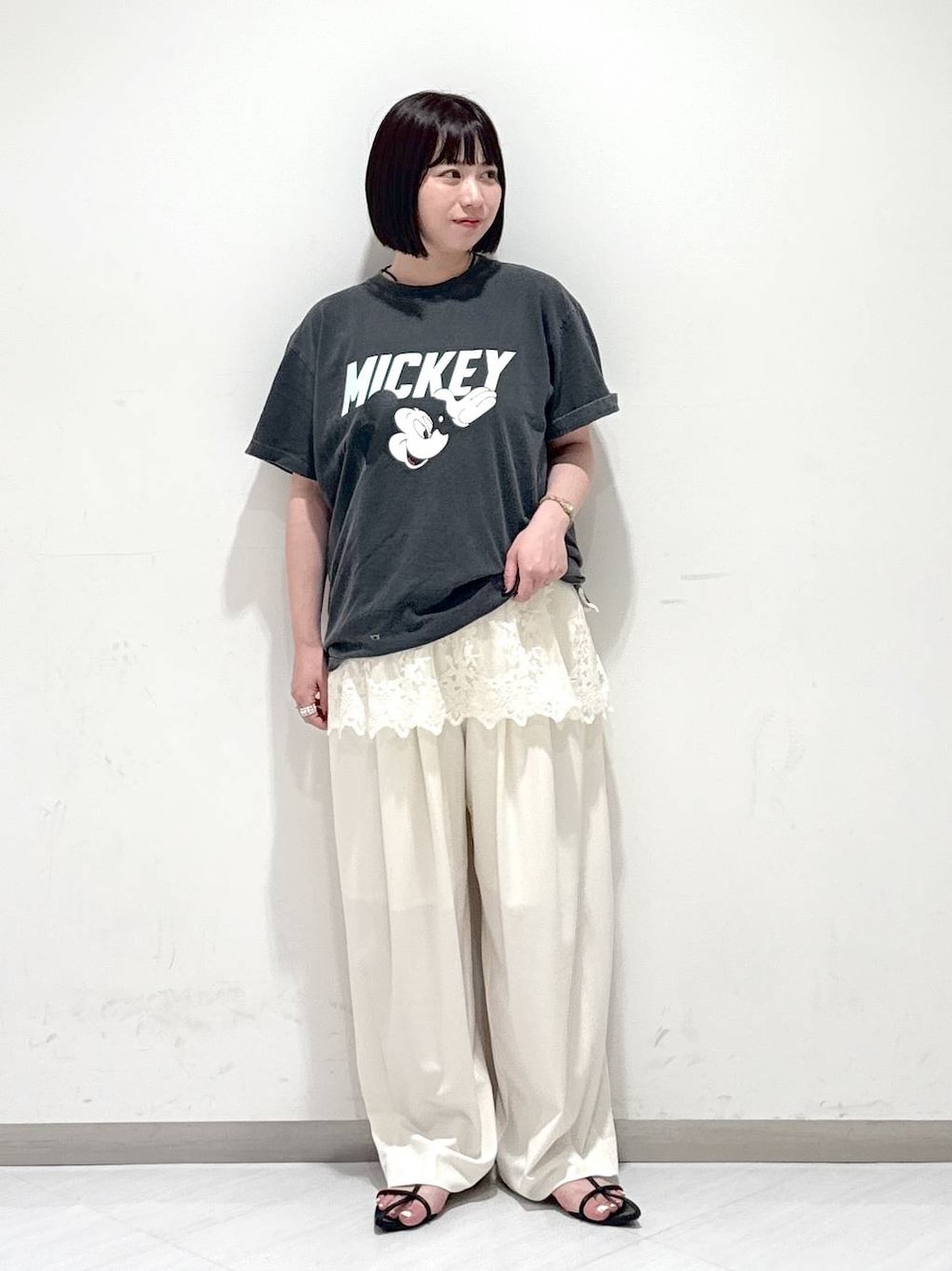ブラック系のサンダル、ホワイト系のスラックス、グレー系のTシャツ/カットソーを着用したレディースの夏コーディネートの1枚目の写真