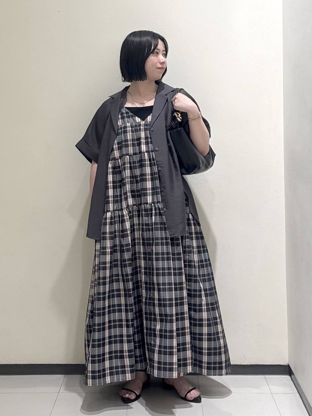 ブラック系のショルダーバッグ、グレー系のシャツ/ブラウス、パープル系のワンピースを着用したレディースの春コーディネートの1枚目の写真