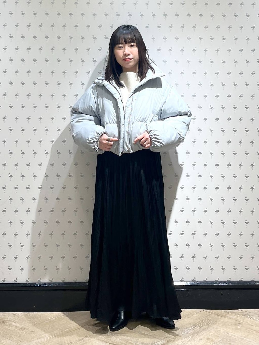 ホワイト系のニット/セーター、ブラック系のブーツ、ブルー系のダウンジャケット/コートを着用したレディースの冬コーディネートの1枚目の写真