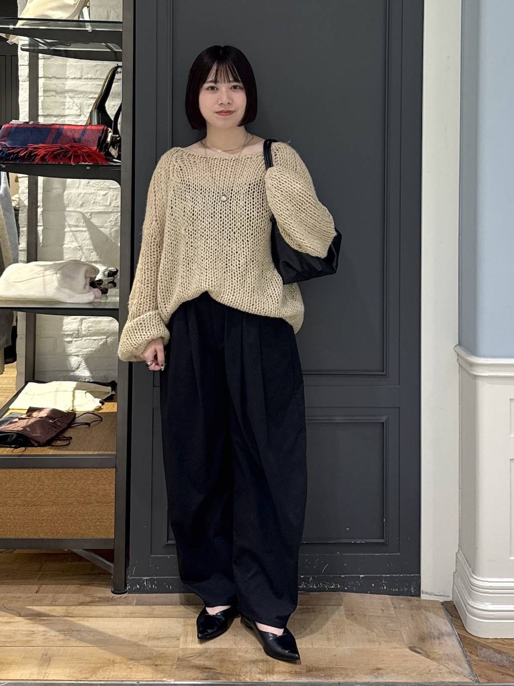 ブラック系のパンプス、ベージュ系のニット/セーター、ブラック系のショルダーバッグを着用したレディースの秋コーディネートの1枚目の写真