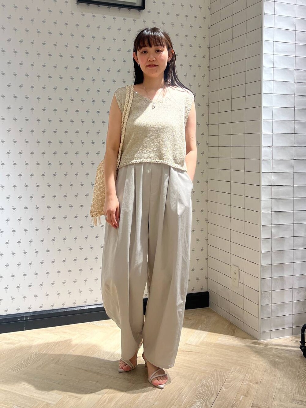 ホワイト系のショルダーバッグ、ホワイト系のサンダル、グレー系のその他パンツを着用したレディースの夏コーディネートの1枚目の写真