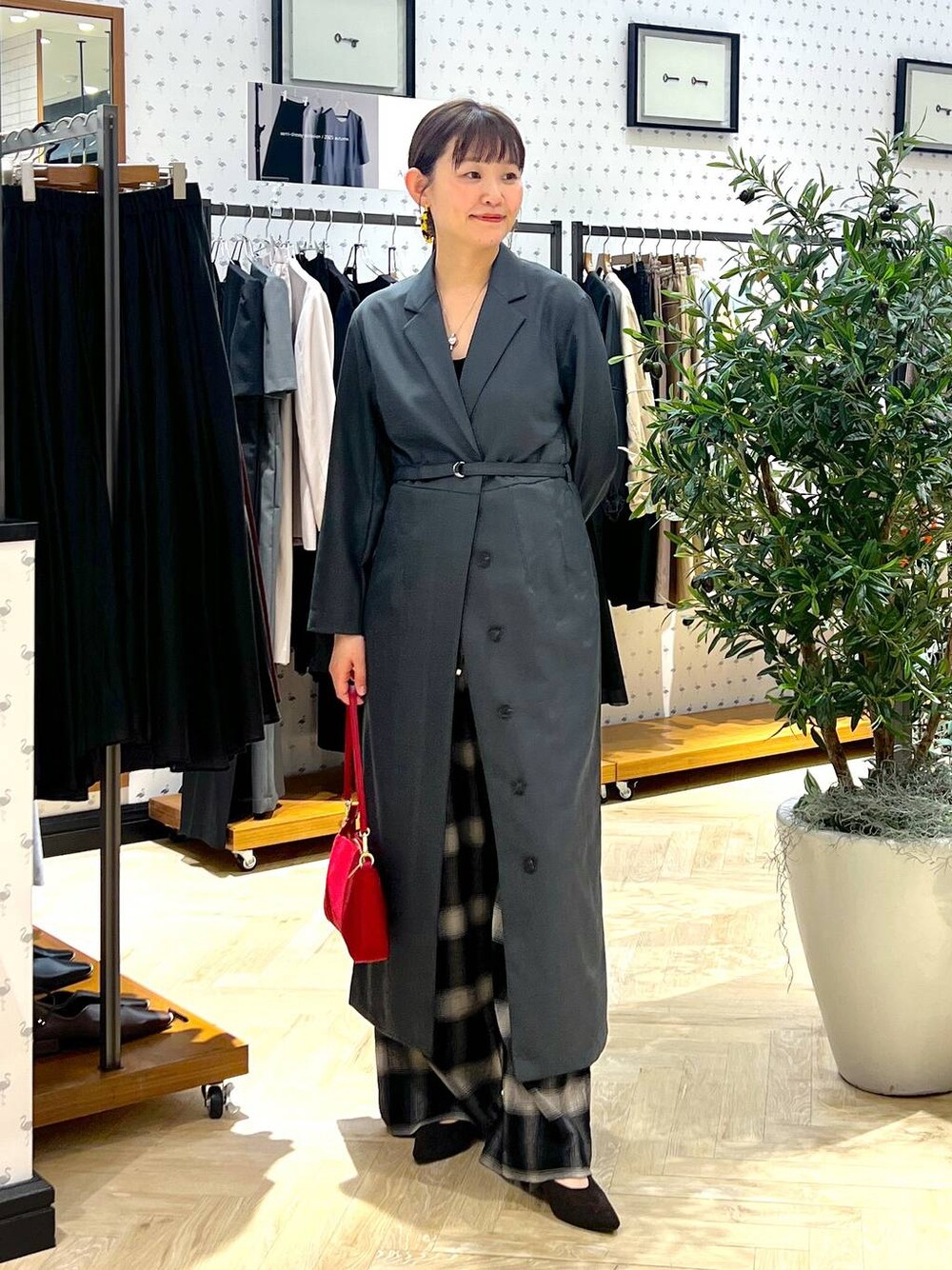 ブラウン系のパンプス、レッド系のショルダーバッグ、ブラック系のその他パンツを着用したレディースの秋コーディネートの1枚目の写真