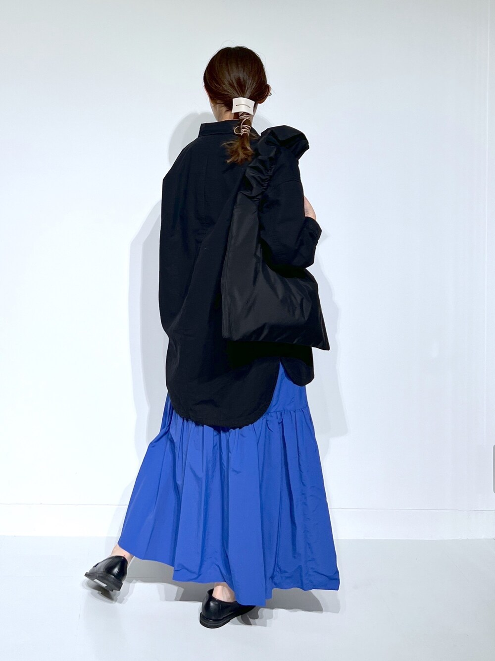 グレー系のTシャツ/カットソー、ブラック系のミリタリージャケット、ブルー系のスカートを着用したレディースの春コーディネートの2枚目の写真