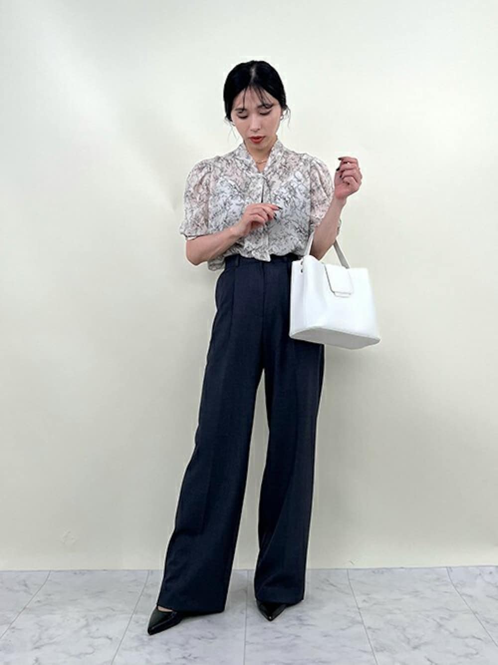 ホワイト系のシャツ/ブラウス、ブラック系のスラックスを着用したレディースの夏コーディネートの1枚目の写真