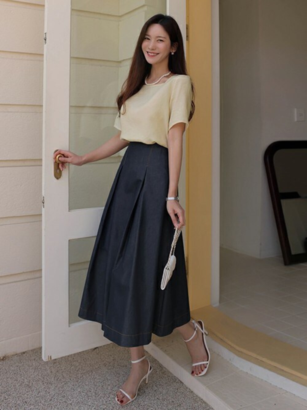ベージュ系のビジネスシャツを着用したレディースの夏コーディネートの1枚目の写真