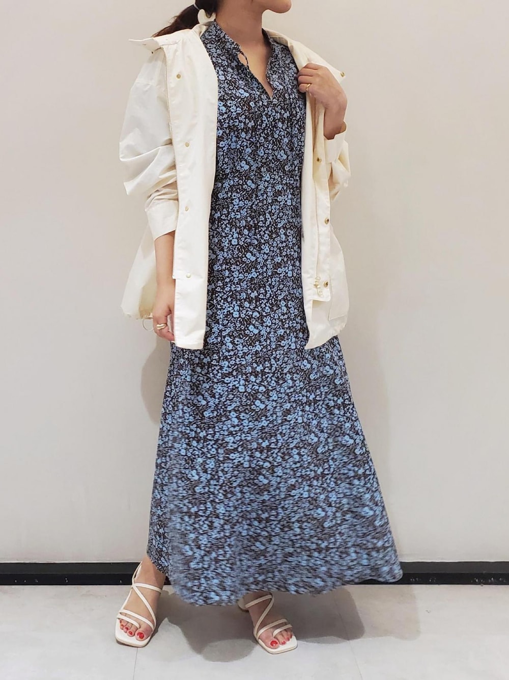 ホワイト系のマウンテンパーカー、ブラウン系のワンピース、ホワイト系のサンダルを着用したレディースの春コーディネートの1枚目の写真