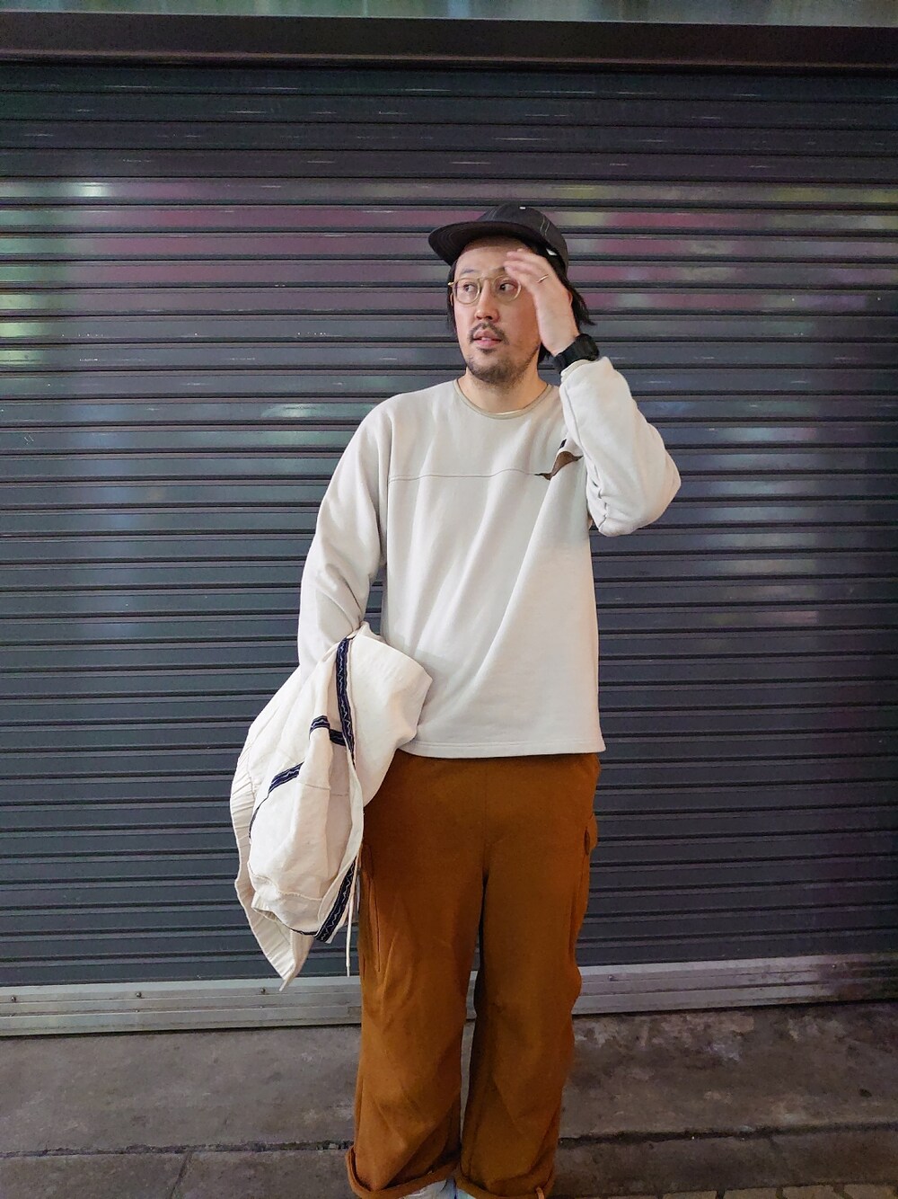 イエロー系のスウェットパンツ、ホワイト系のサンダル、ベージュ系のスウェットを着用したメンズの冬コーディネートの2枚目の写真