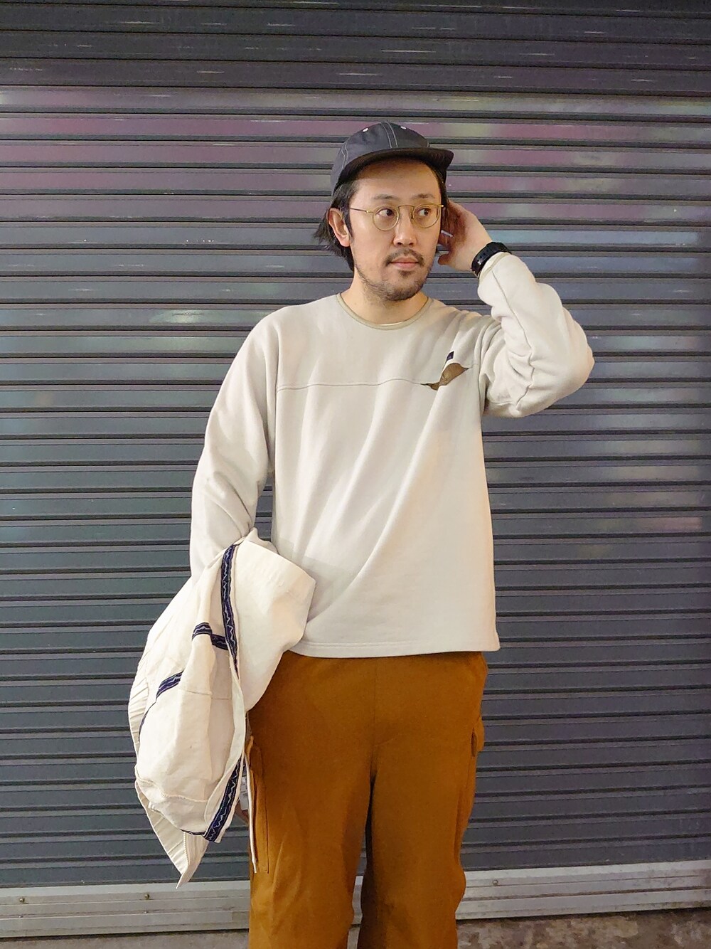 イエロー系のスウェットパンツ、ホワイト系のサンダル、ベージュ系のスウェットを着用したメンズの冬コーディネートの3枚目の写真