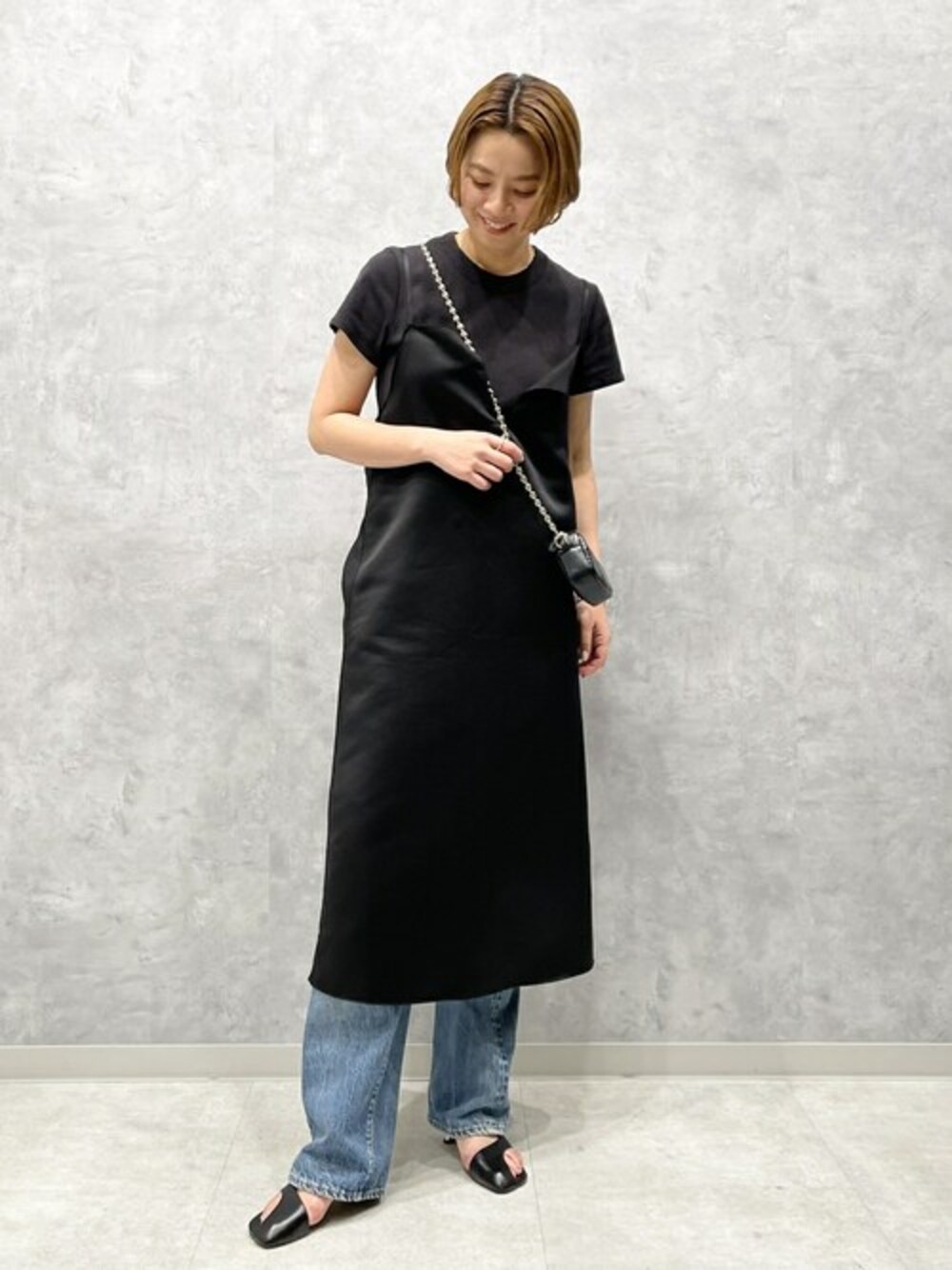 ブラック系のサンダル、ブラック系のショルダーバッグを着用したレディースの春コーディネートの1枚目の写真