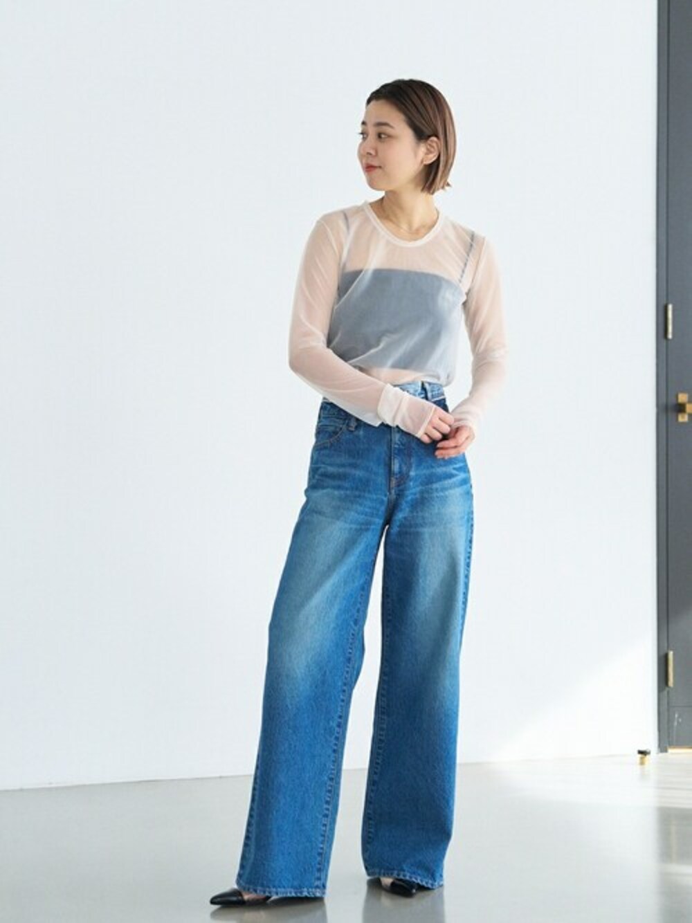 ブラック系のパンプスを着用したレディースの冬コーディネートの1枚目の写真