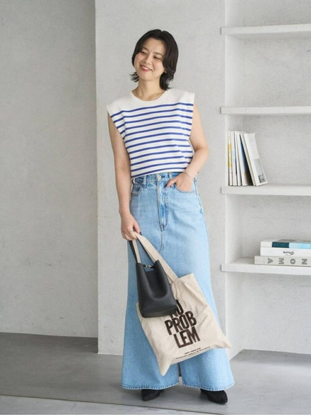 ブラック系のパンプス、ベージュ系のトートバッグを着用したレディースの夏コーディネートの1枚目の写真