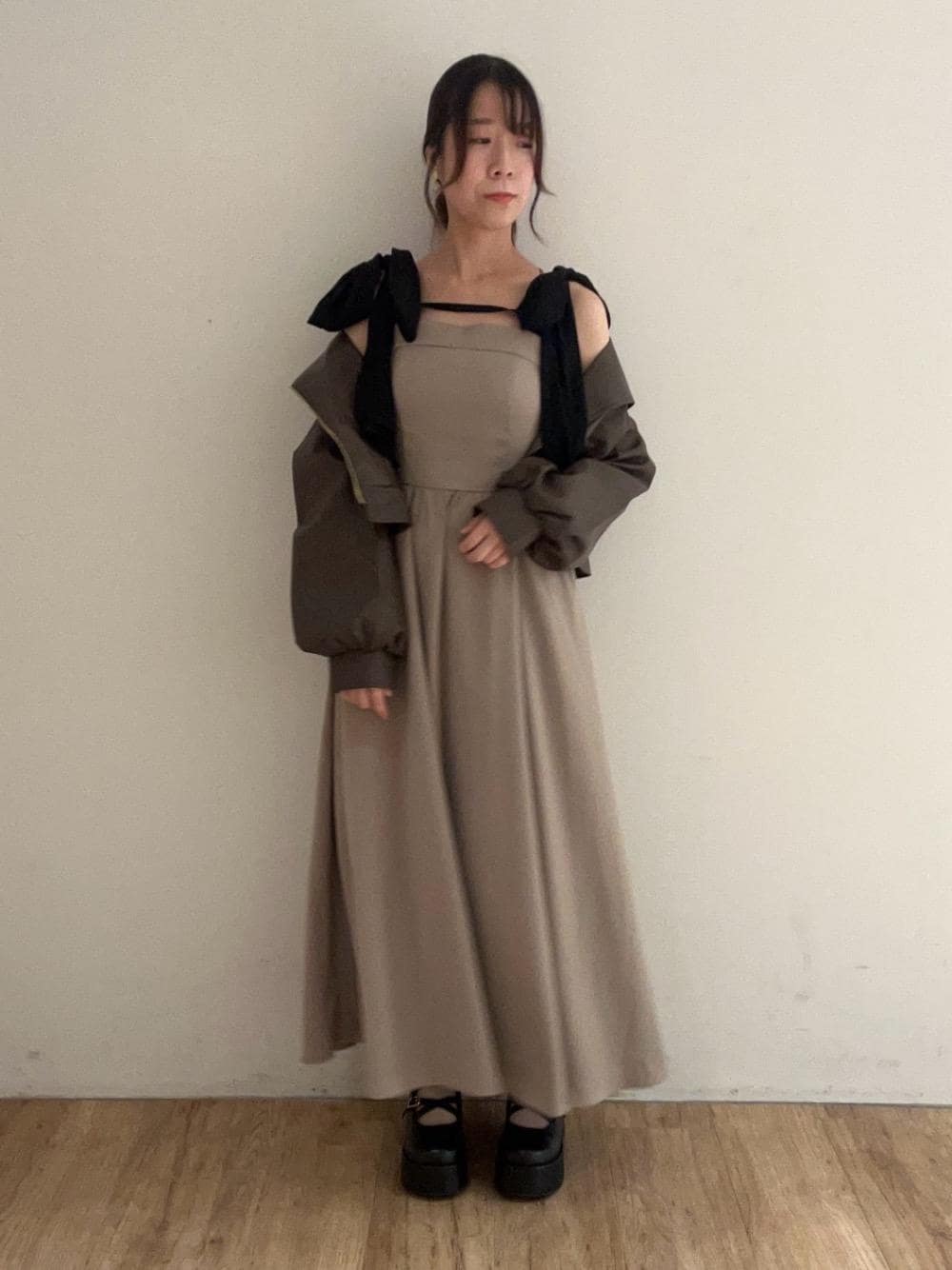 ブラウン系のブルゾン、ブラック系のその他シューズ、ベージュ系のワンピースを着用したレディースの秋コーディネートの1枚目の写真