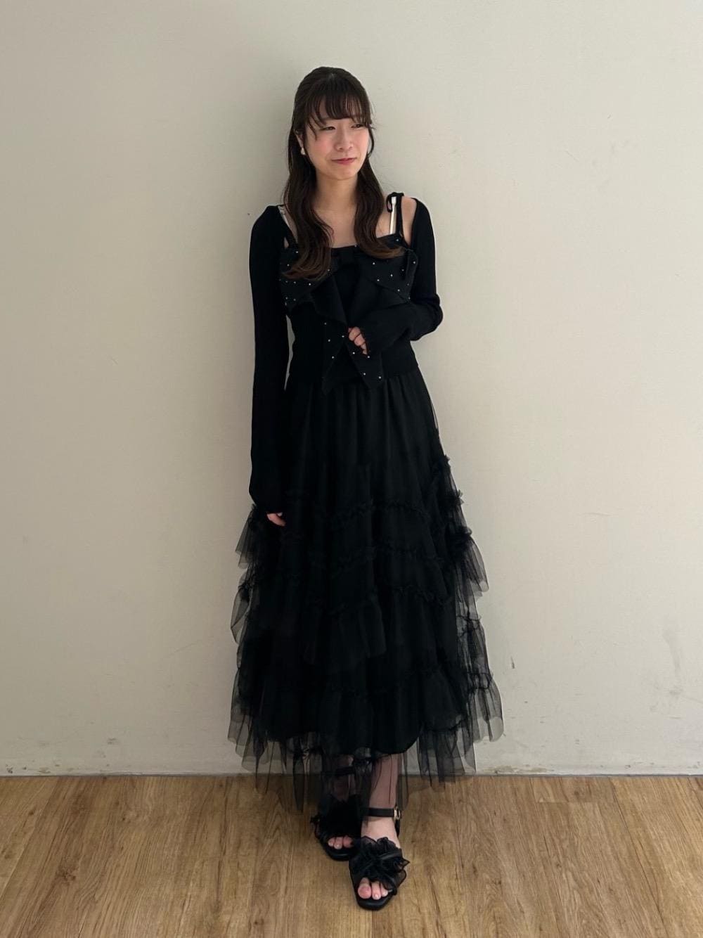 ブラック系のサンダル、ブラック系のスカートを着用したレディースの夏コーディネートの1枚目の写真