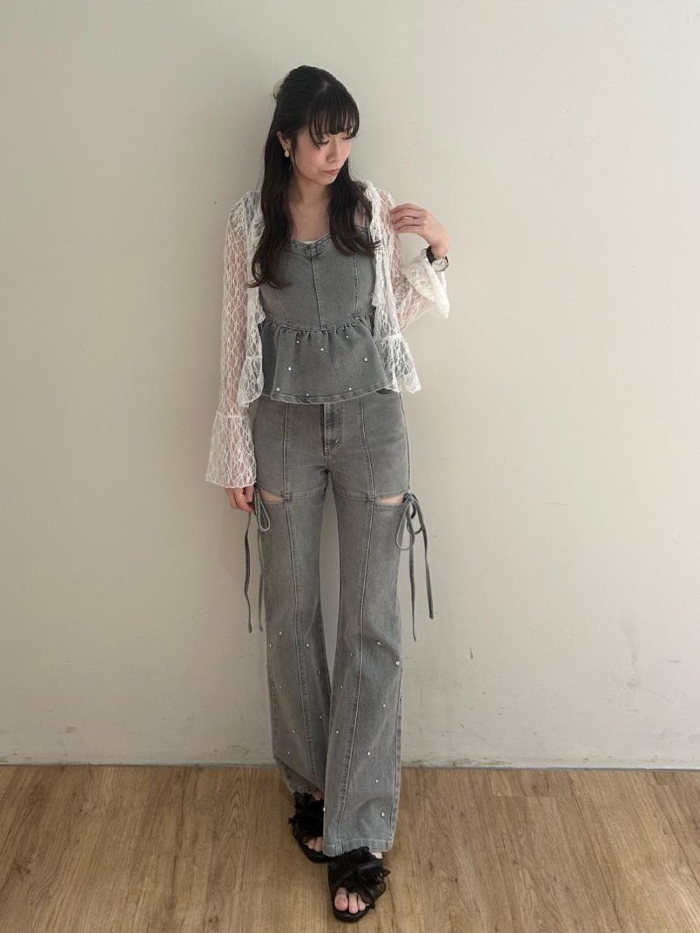 グレー系のデニムパンツ、グレー系のキャミソール、ブラック系のサンダルを着用したレディースの夏コーディネートの1枚目の写真