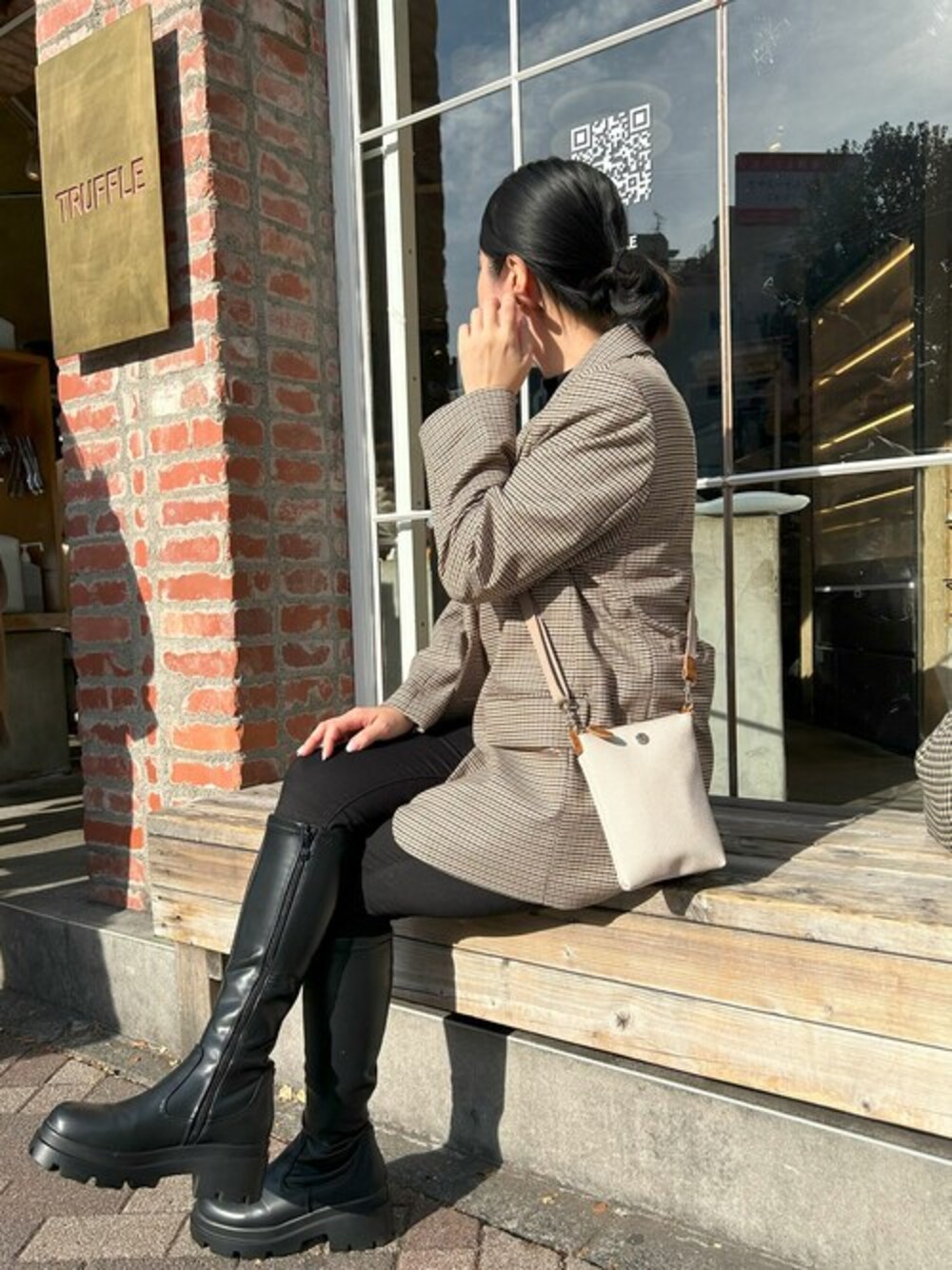 ベージュ系のショルダーバッグを着用したレディースの冬コーディネートの1枚目の写真