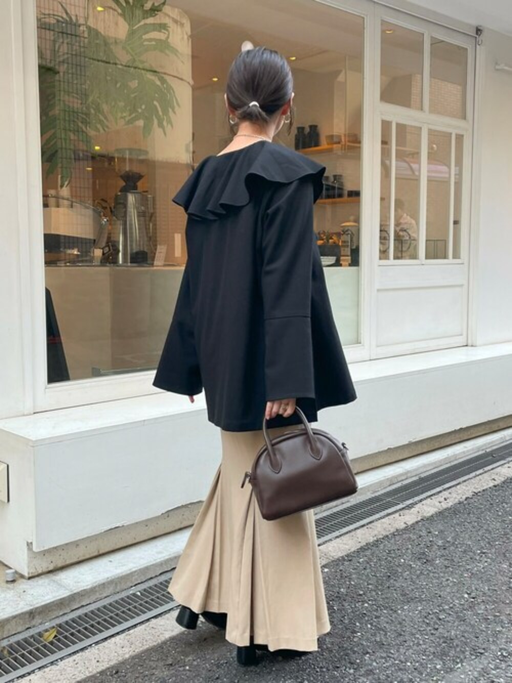 ブラウン系のボストンバッグを着用したレディースの冬コーディネートの1枚目の写真