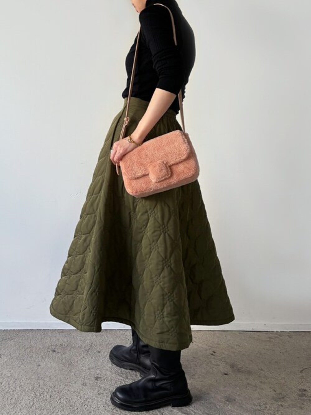 ピンク系のショルダーバッグを着用したレディースの冬コーディネートの1枚目の写真