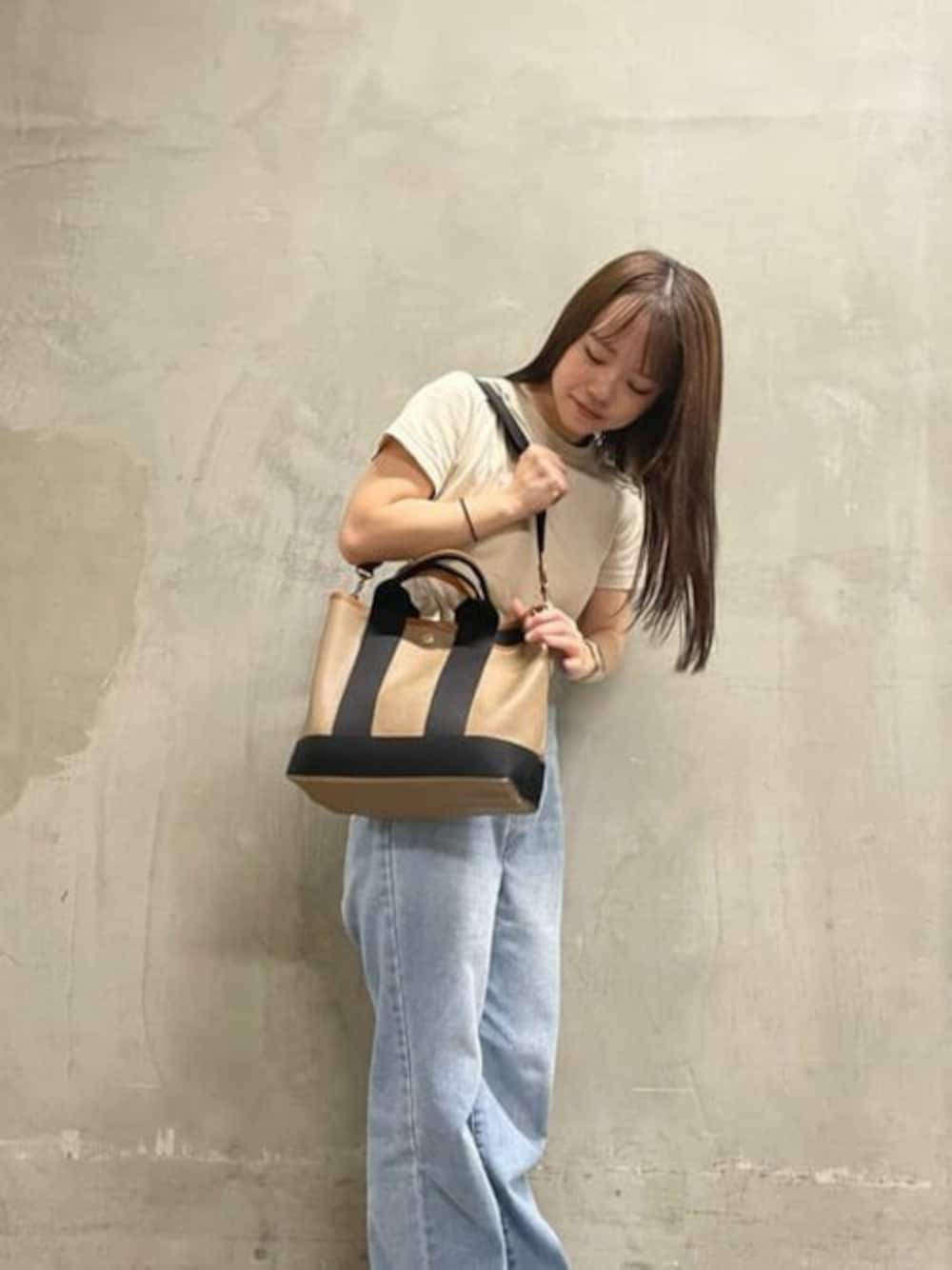 ブラウン系のトートバッグを着用したレディースの冬コーディネートの1枚目の写真