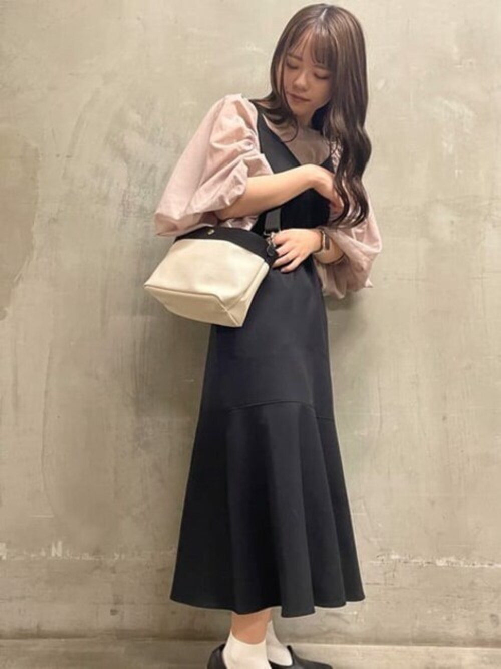 ホワイト系のショルダーバッグを着用したレディースの冬コーディネートの1枚目の写真