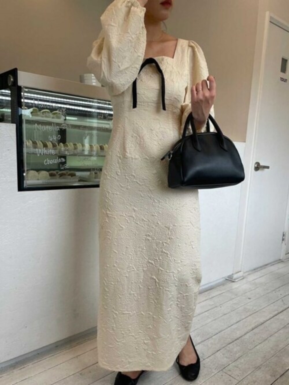 ブラック系のボストンバッグを着用したレディースの冬コーディネートの1枚目の写真