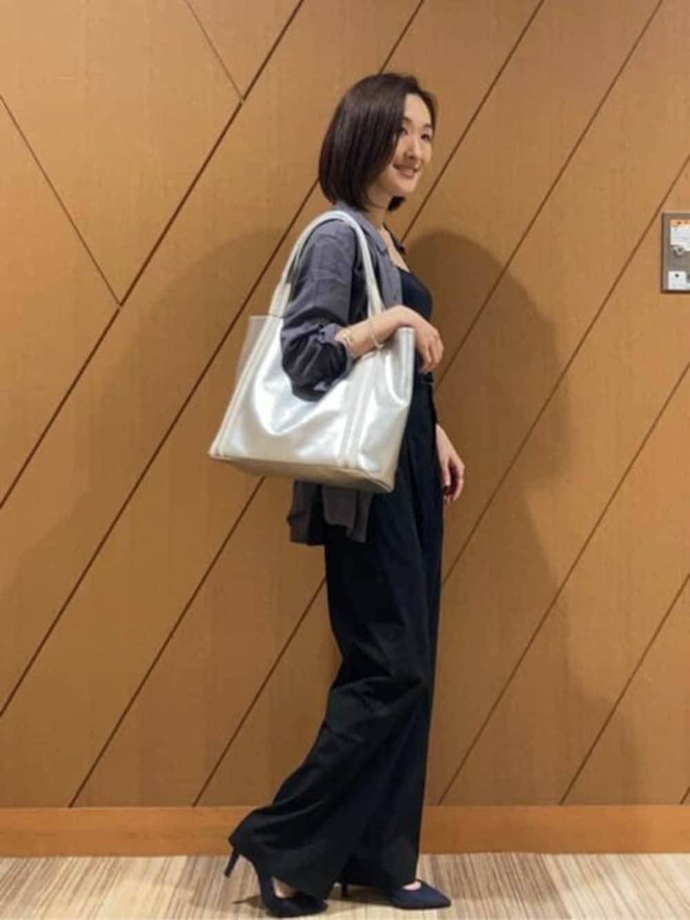 シルバー系のトートバッグを着用したレディースの冬コーディネートの1枚目の写真