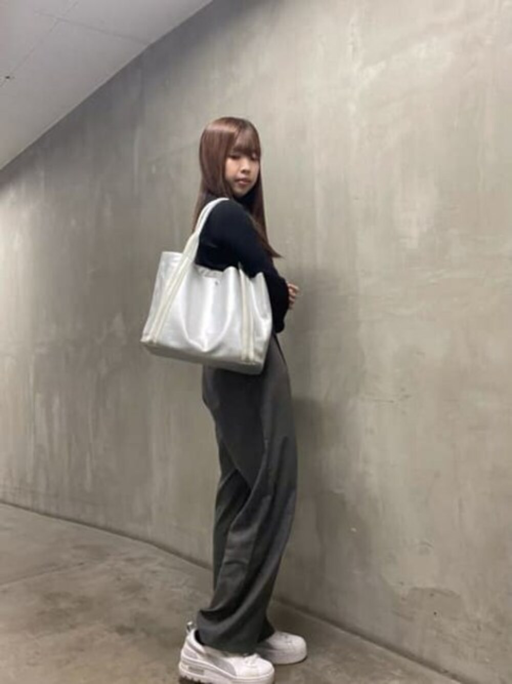 シルバー系のトートバッグを着用したレディースの冬コーディネートの1枚目の写真