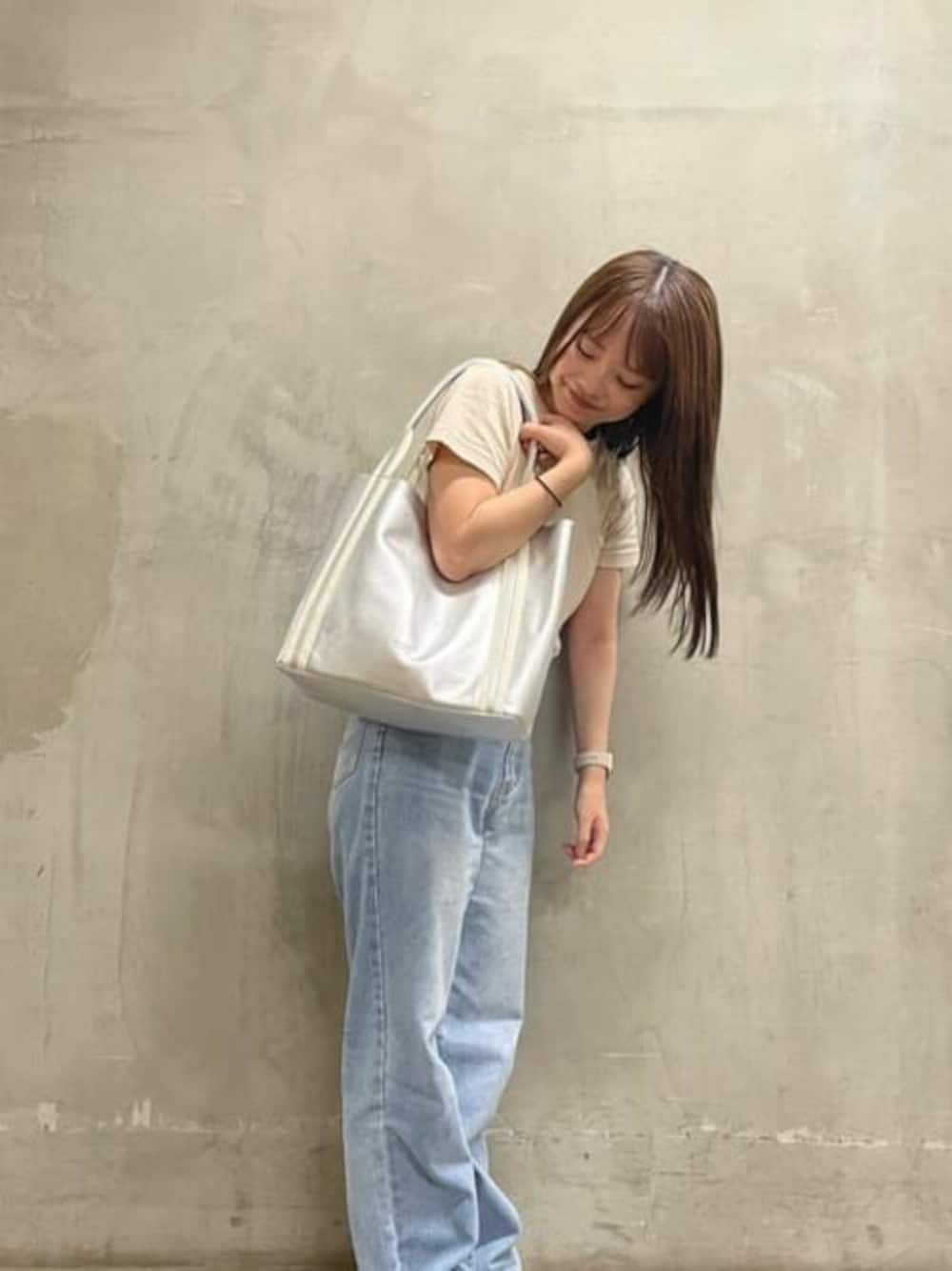 シルバー系のトートバッグを着用したレディースの冬コーディネートの1枚目の写真