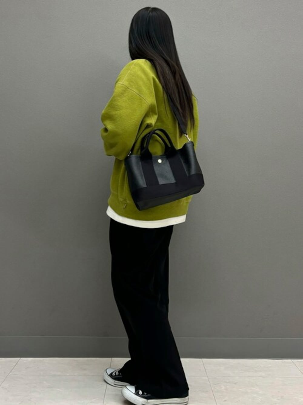 ブラック系のトートバッグを着用したレディースの春コーディネートの1枚目の写真