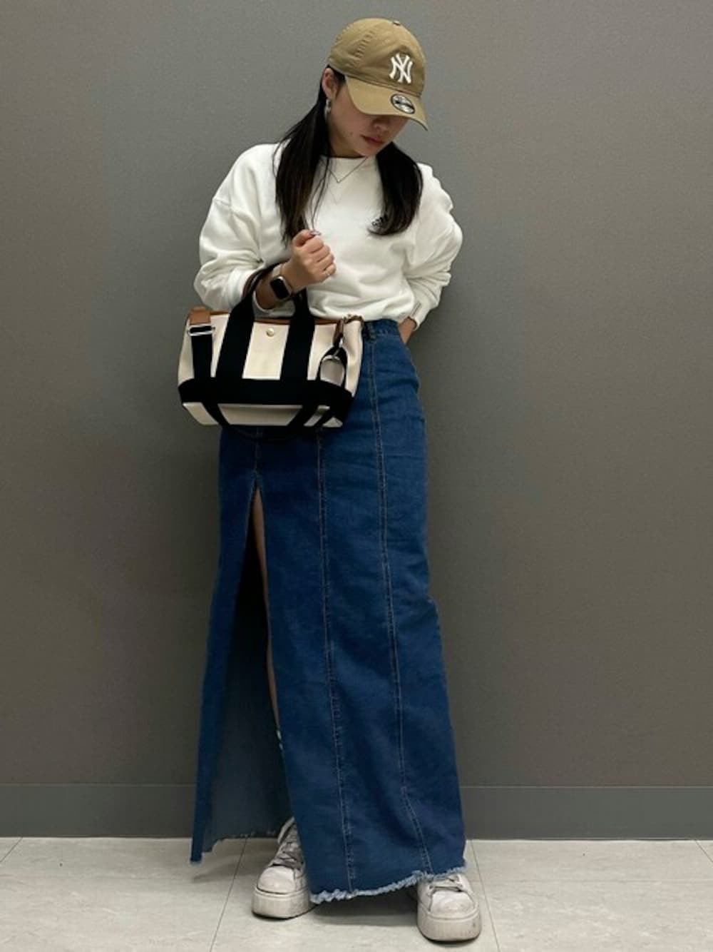 ベージュ系のトートバッグを着用したレディースの春コーディネートの1枚目の写真