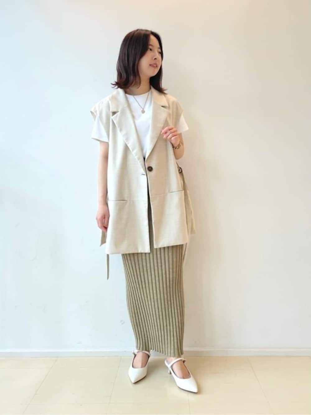 ホワイト系のパンプスを着用したレディースの夏コーディネートの1枚目の写真