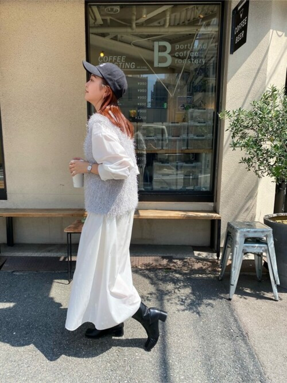 グレー系のベスト、ホワイト系のシャツワンピースを着用したレディースの冬コーディネートの1枚目の写真