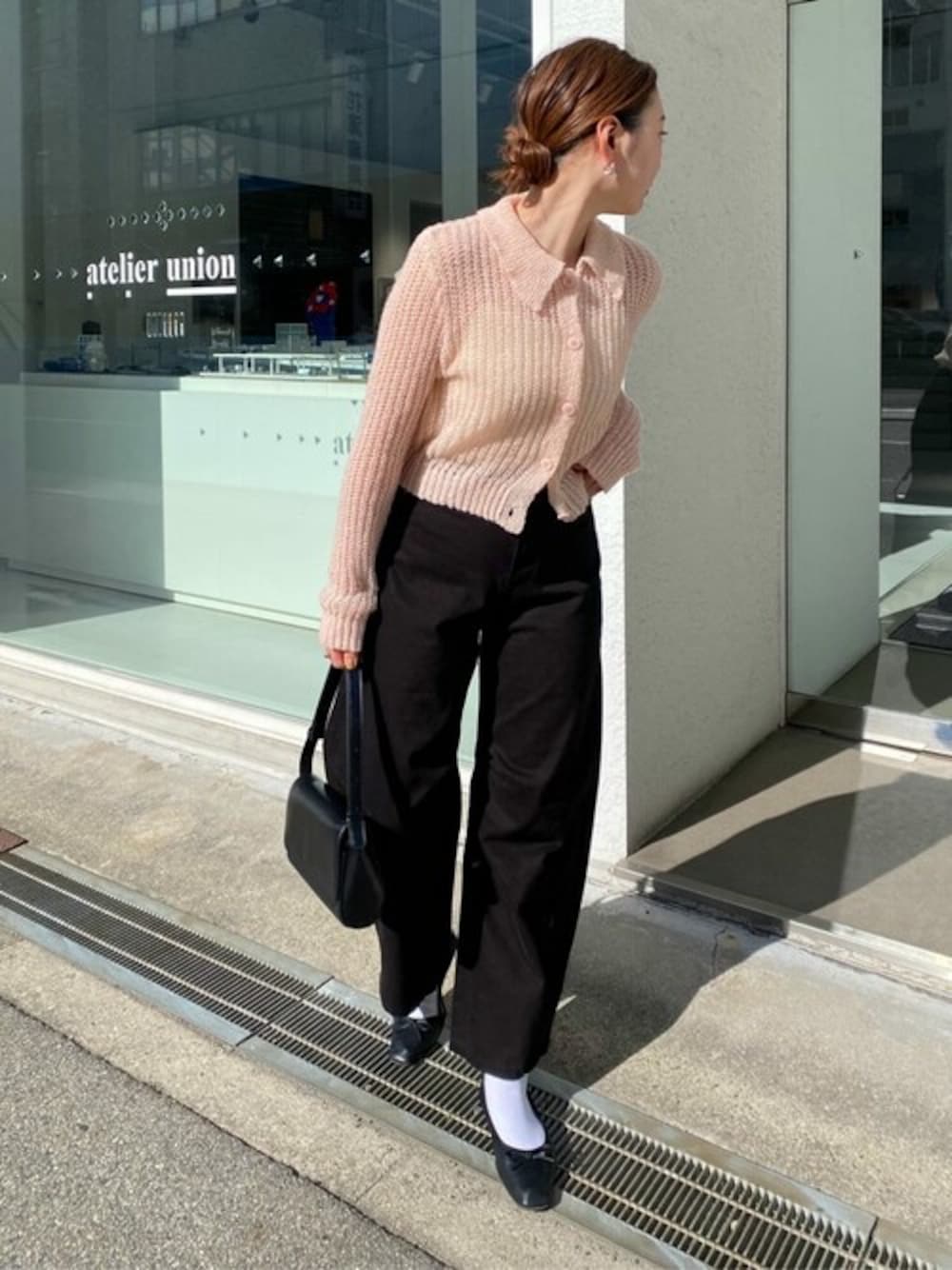 ピンク系のニット/セーター、ブラック系のデニムパンツ、ブラック系のバレエシューズを着用したレディースの冬コーディネートの1枚目の写真