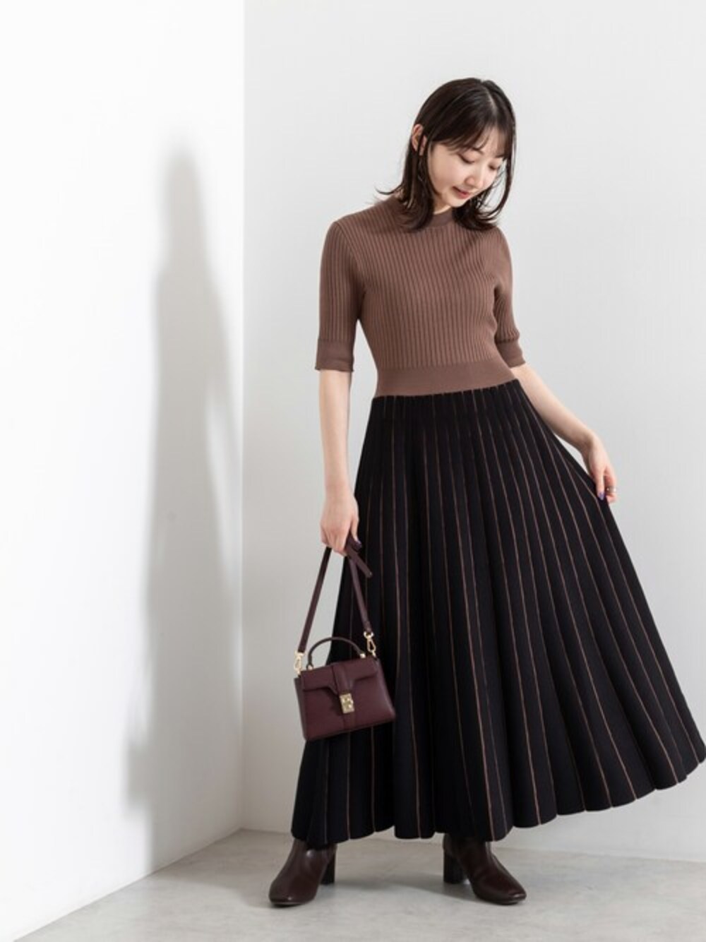 ブラウン系のワンピース、レッド系のショルダーバッグ、ブラウン系のブーツを着用したレディースの夏コーディネートの1枚目の写真