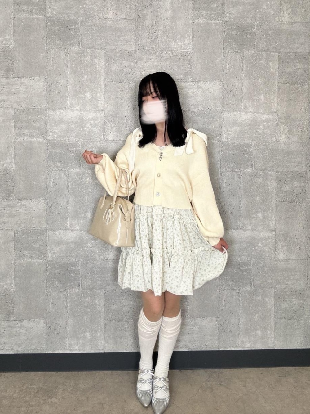 シルバー系のパンプス、ホワイト系のボストンバッグ、ホワイト系のカーディガン/ボレロを着用したレディースの春コーディネートの1枚目の写真
