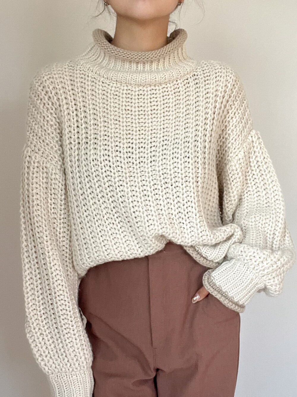 ブラウン系のパンツ、ホワイト系のニット/セーターを着用したレディースの秋コーディネートの1枚目の写真